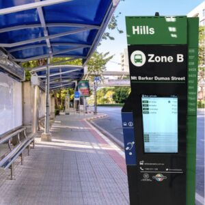 This is an image of a digital Bus stop totem used as a transportation digital display with built in voice annunciator and hearing loop by metrospec installed at a bus stop.