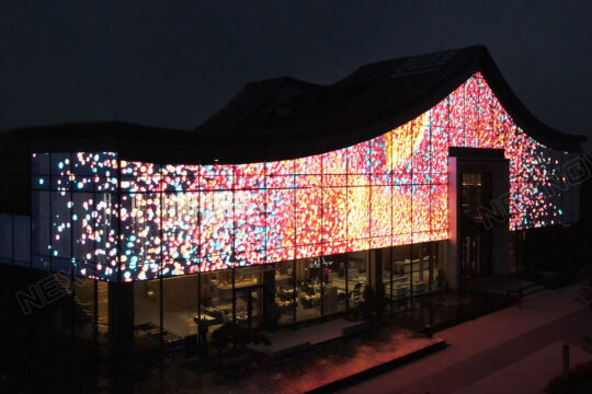 This is an image of a transparent LED screen installed behind the glass facade of a building.