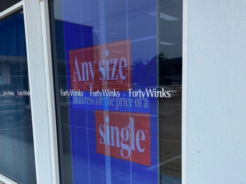 This is an image of the Metrospec Transparent LED Display used for Retail Advertising in Kawana, QLD at Forty Winks Shop Front
